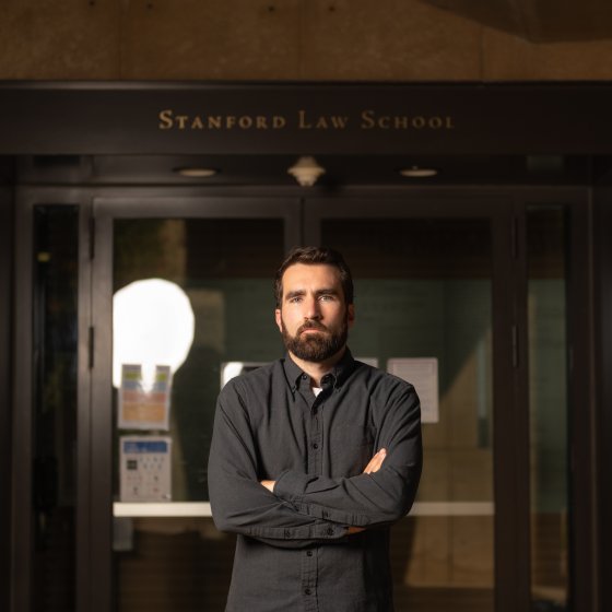 Stanford Law School student Nicholas Wallace stands before the school entrance