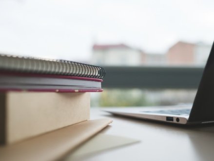 open laptop computer and notebooks on a table