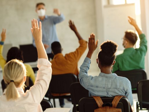 Students raising hands in class