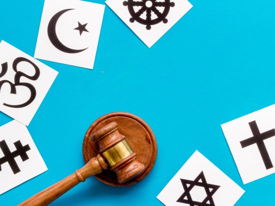 World religions symbols near gavel on blue background